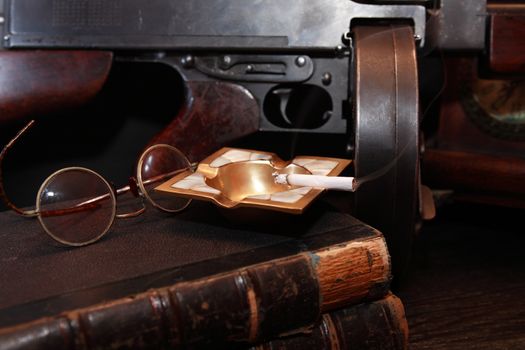 Old USA submachine gun closeup with books and spectacles