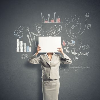 Businesswoman hiding her face behind sheet of paper