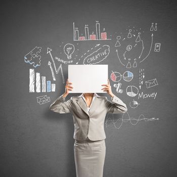 Businesswoman hiding her face behind sheet of paper