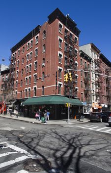 Red brick building, with corner store, against blue sky in New York city