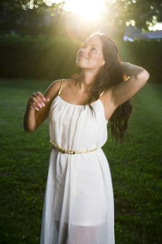 twenty something woman wearing a white dress with sun over her head