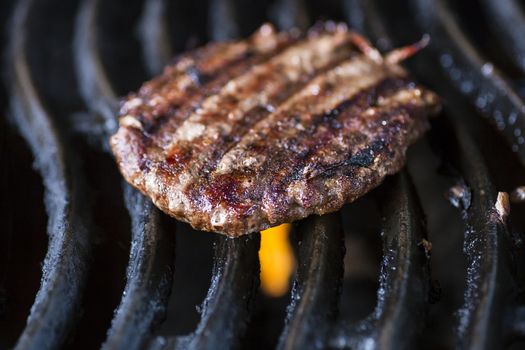 macro shot of a hamburger pattie on a bbq grill