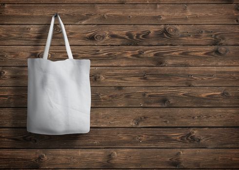 shopping bag of cotton weighs on the screw on wooden background