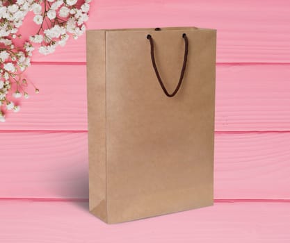 paper bag for shopping on a wooden pink background