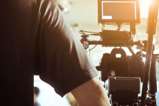 Cameraman with his video camera shooting, Adjusting Camera,film production cre. behind the scenes background.