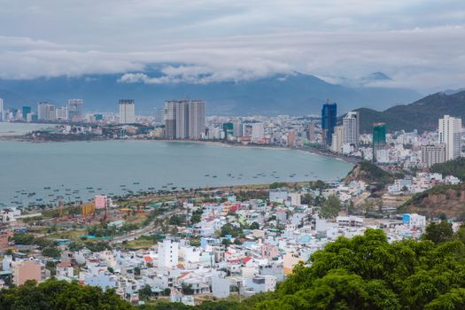 Holiday resort Nha Trang Vietnam on a cloudy day from a view point north of the city. With the mountains in the background and the turquoise south china sea to the left.