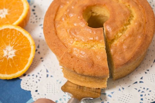 Homemade orange cake on a table with fruit sliced.