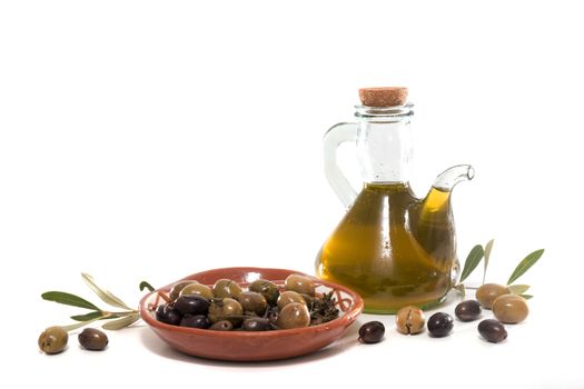 Green and black olives with olive oil bottle isolated on a white background.
