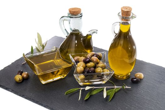 Green and black olives with olive oil bottles isolated on a white background.