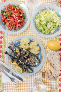 Grilled atlantic horse mackerel meal with salad and potatoes.