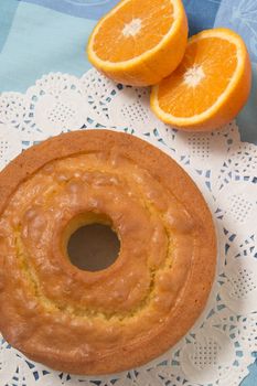 Homemade orange cake on a table with fruit sliced.
