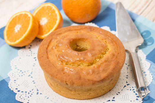 Homemade orange cake on a table with fruit sliced.