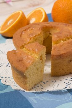 Homemade orange cake on a table with fruit sliced.