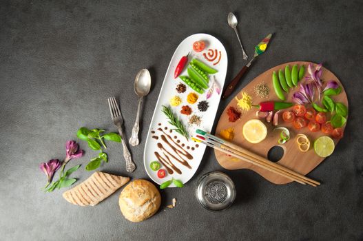 Colorful herbs spices and fresh ingredients on a painters palette 