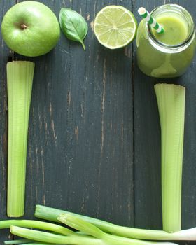 Blended smoothie with fresh ingredients on a wooden table with space for text 