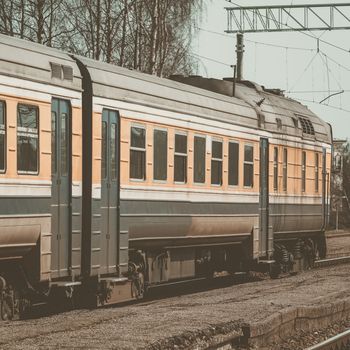 Old yellow passenger diesel train moving at the terminal