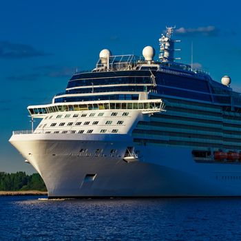 White giant brand new passenger ship moving in clear summer day