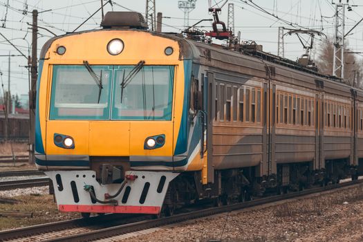 Yellow modern passenger electric train moving at the old terminal