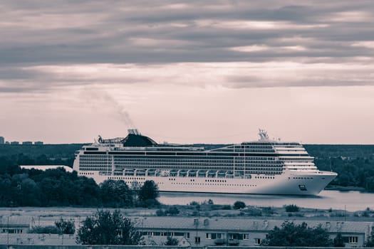 Large cruise liner sailing past the cargo port. Monochrome