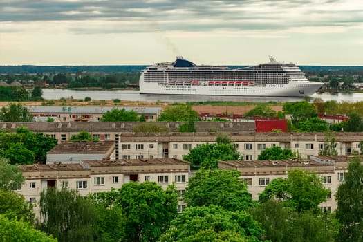 Big white cruise liner sailing past the cargo port