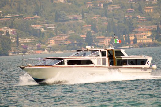 Recreational yacht flying Portuguese flag spinning on Lake Garda in Italy