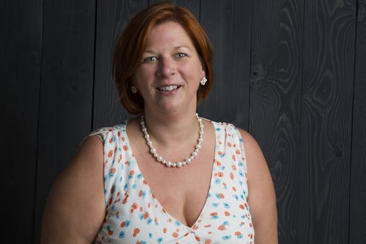 woman in her forties against a wood stained background