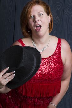 sexy forty year old woman wearing a sparkly dress and holding a black hat