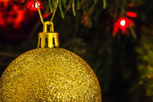 Various Christmas tree decorations and red blurred light on background