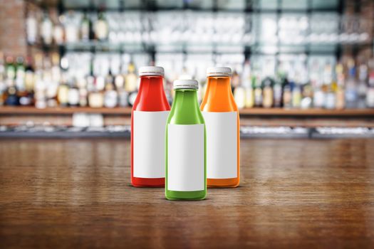three multicolored bottles of juice are on the counter