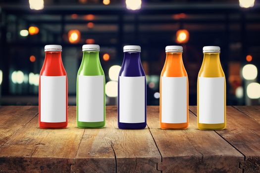 five multicolored bottles of juice are on the counter