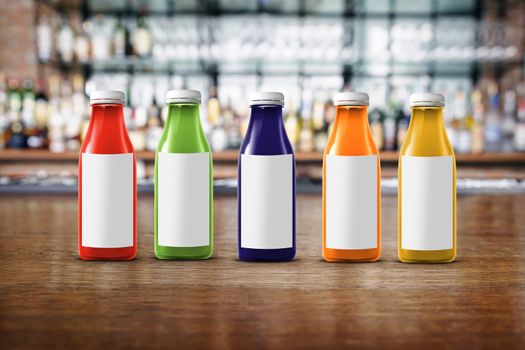 five multicolored bottles of juice are on the counter