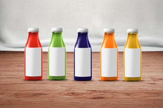 five multicolored bottles of juice are on the counter