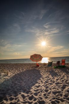 Umbrellas along Vanderbilt Beach in Naples, Florida, USA at sunset