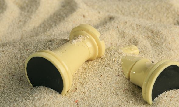 Chess pieces in a sand dune