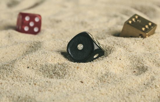 some dices buried in the sand dunes