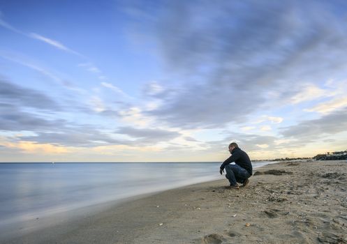 man sitting in a Long exposure photography on  the beach