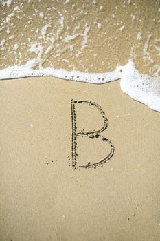 Letter drawn on the sand beach