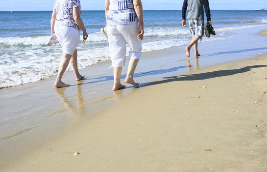 Old people taking a walk on the beach