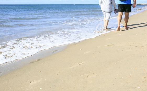 Old people taking a walk on the beach