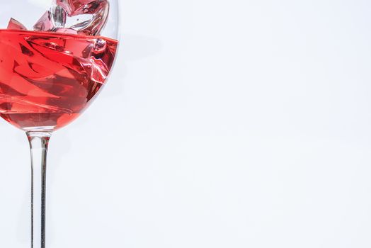 Glass cup with red liquid and ice