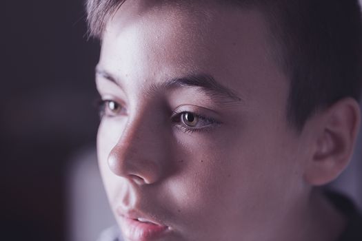 Boy with green eyes looking at the television