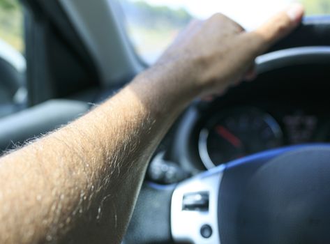 hand of Man driving his car