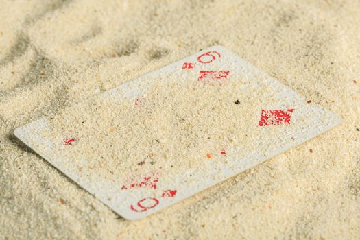 Poker playing cards buried  in a sand dune