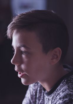 Boy with green eyes looking at the television