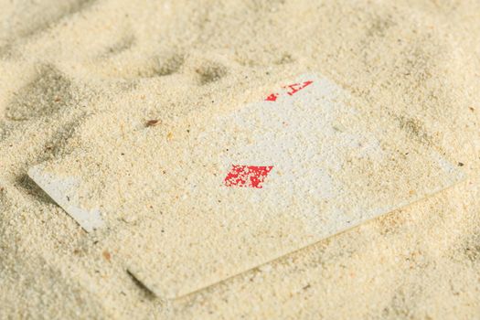 Poker playing cards buried  in a sand dune