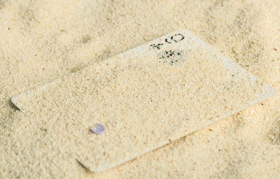 Poker playing cards buried  in a sand dune