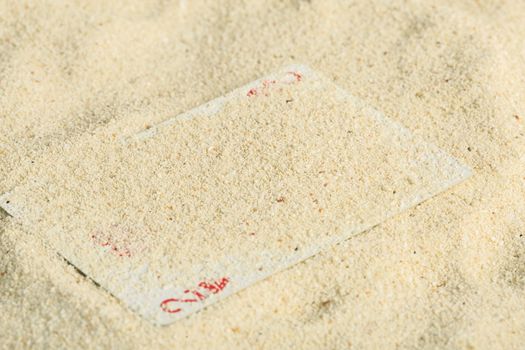 Poker playing cards buried  in a sand dune