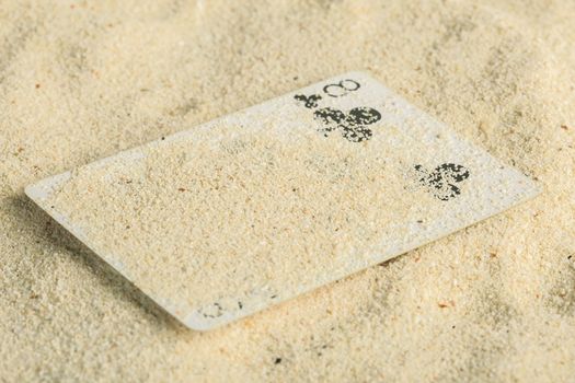 Poker playing cards buried  in a sand dune