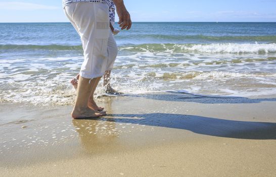 Old people taking a walk on the beach