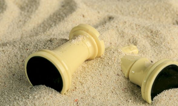 Chess pieces in a sand dune